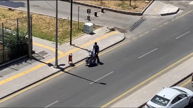 Tekerlekli sandalyeyle gitmekte zorlanan kadına polis yardım etti