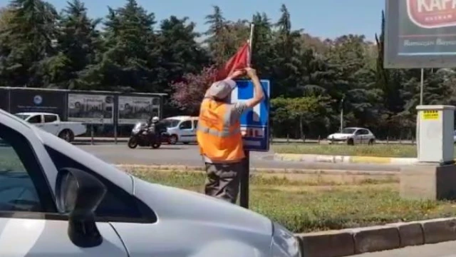 Yerde bulduğu Türk bayrağını temizleyip, tabelaya astı